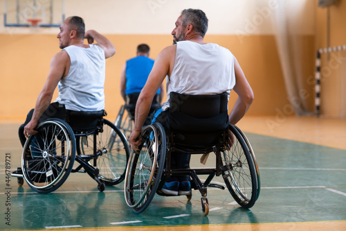 handicapped war veterans in wheelchairs with professional equipment play basketball match in the hall.the concept of sports with disabilities © .shock