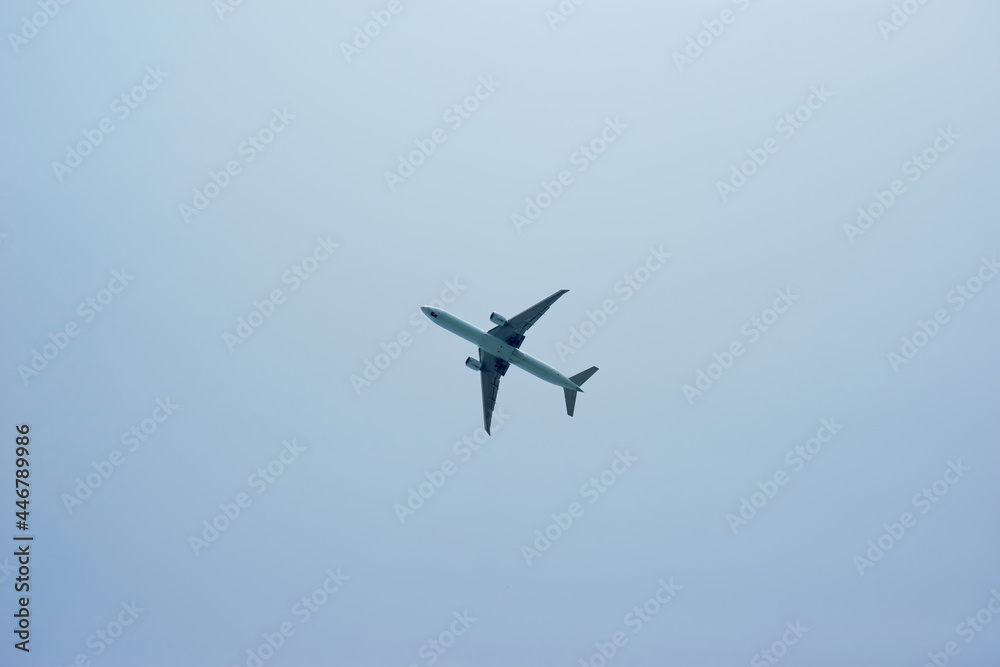 Black silhouette of a passenger plane in the blue sky Black silhouette of a passenger plane in the blue sky