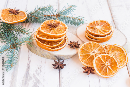 christmas festivw background with fir tree branches, dried oranges and anise stars on rustic wooden table