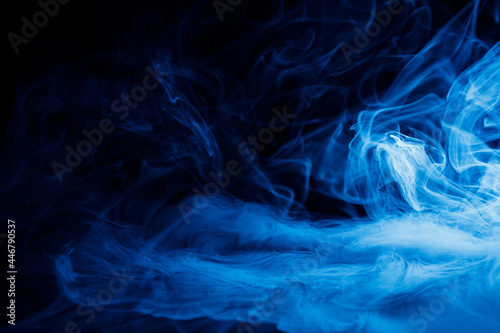 Art photo of blue smoke moves on black background. Beautiful swirling smoke.
