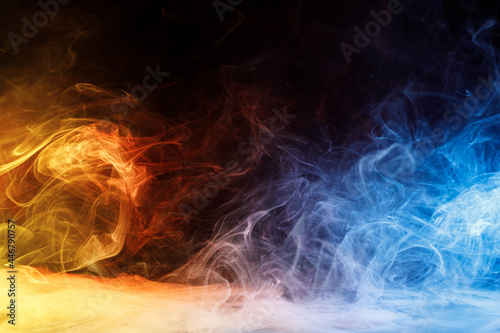 Art photo of colorful smoke moves on black background. Beautiful swirling colorful smoke.
