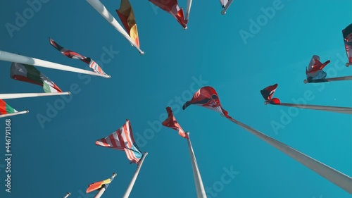 Different flags fluttering on flagpoles photo