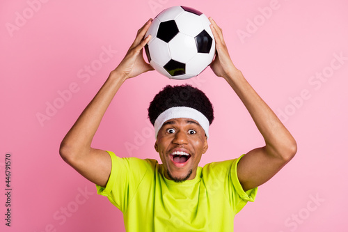 Portrait of attractive cheerful guy throwing ball pass playing soccer hobby isolated over pink pastel color background © deagreez