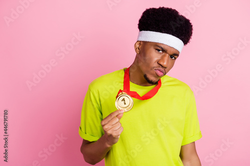Photo of young arrogant afro guy sportsman show gold medal victory isolated over pink color background © deagreez