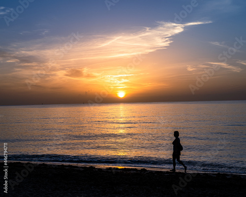 silhouette of a person on the beach at sunrise
