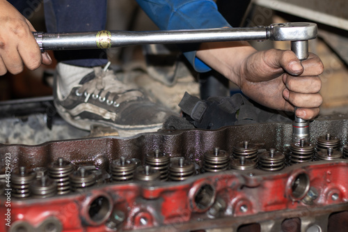 The mechanic is checking the engine.