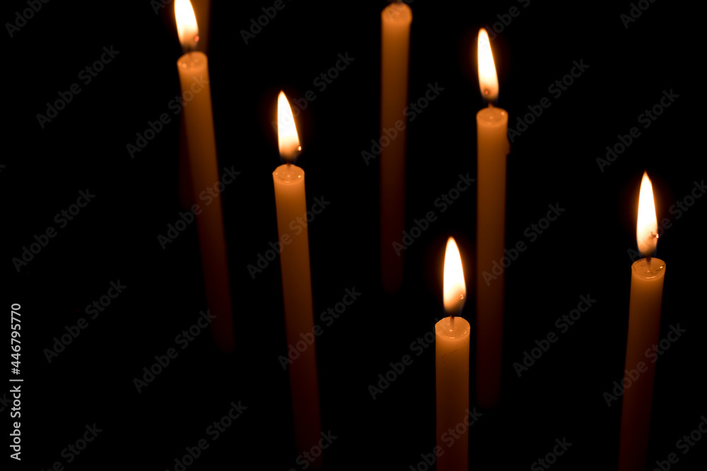 Several candles lit in the dark for religious purposes. Several candles lit in the dark for religious purposes.