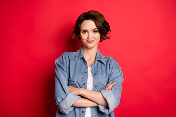 Photo of nice brunette young lady crossed arms wear jeans shirt isolated on red color background