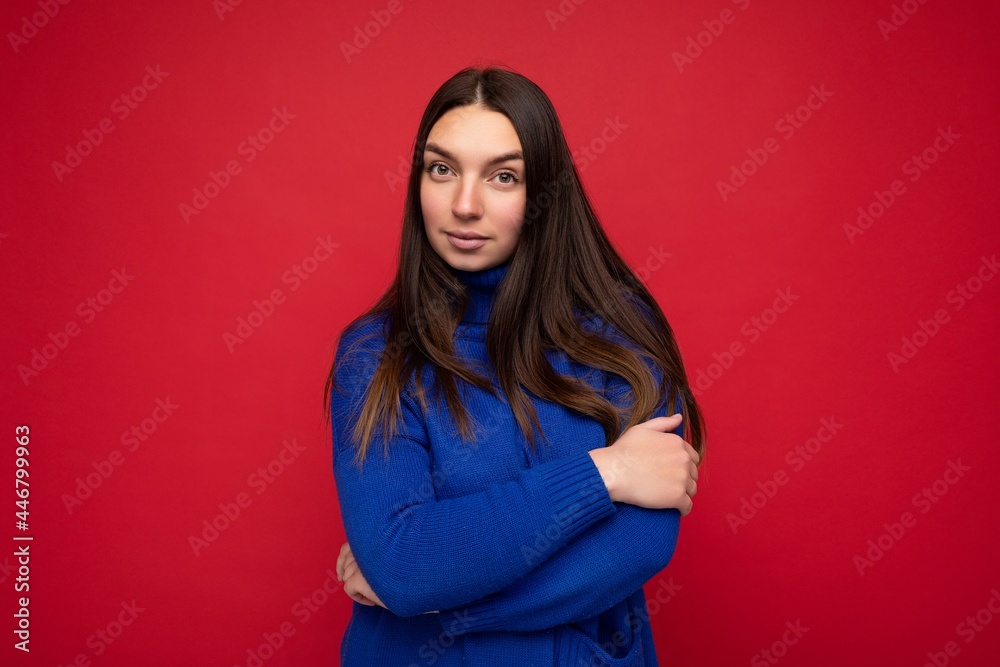Young calm self-confident serious beautiful brunette woman with sincere emotions isolated on background wall with copy space wearing casual trendy blue sweater. Emotions concept Young calm self-confident serious beautiful brunette woman with sincere emotions isolated on background wall with copy space wearing casual trendy blue sweater. Emotions concept