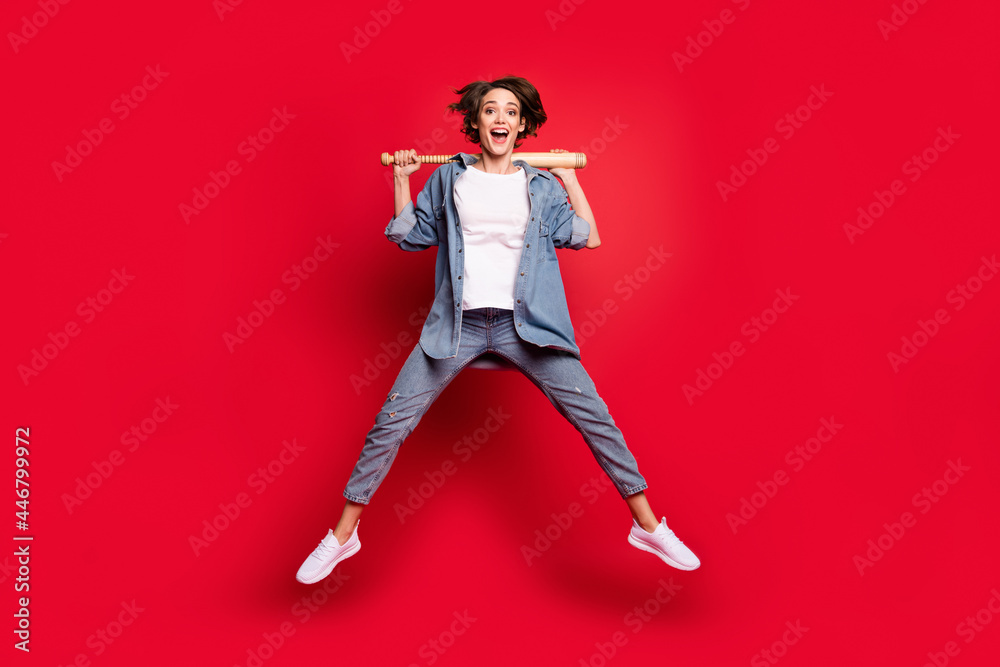 Full length photo of young woman happy positive smile hold baseball bat player isolated over red color background