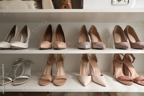 Different stylish women's shoes on shelving unit