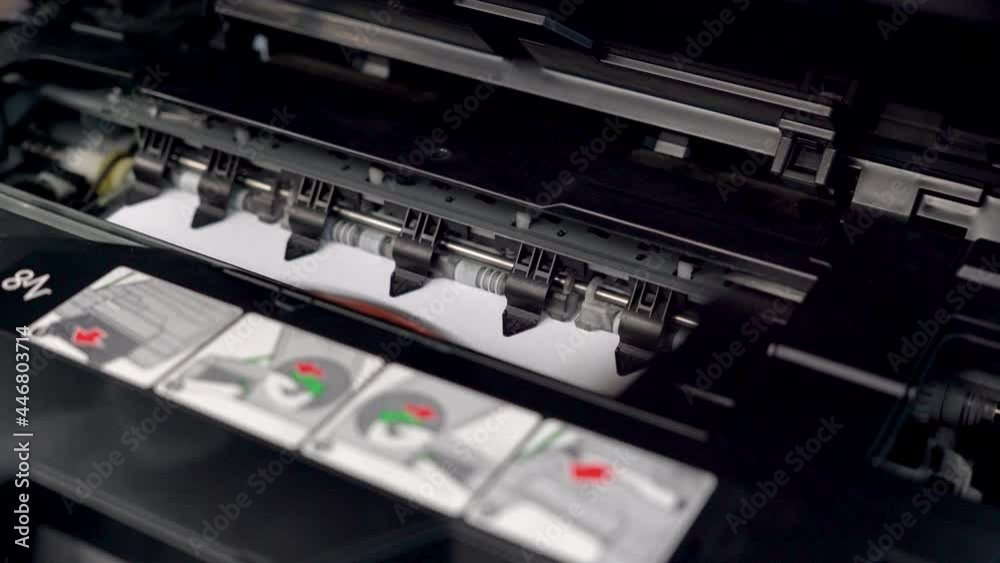 The printhead of the inkjet printer is working. and is printing something on white paper. The printhead of the inkjet printer is working. and is printing something on white paper.