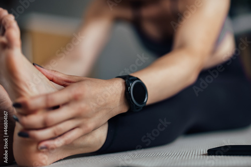 Young woman, using a watch to time her reps.