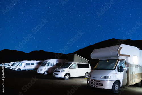 Fotografiet Campers in a caravan parking area on a starry night in the mountain
