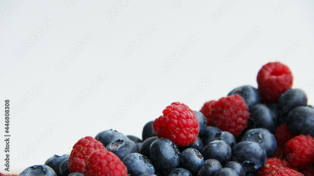 fresh raspberries and blueberries on a white background close-up fresh raspberries and blueberries on a white background close-up