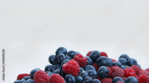 fresh raspberries and blueberries on a white background close-up