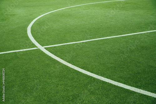 A green football field. A field of artificial grass in a school or public park.