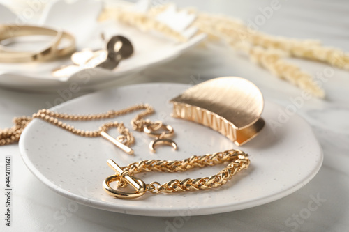 Different elegant bijouterie on white marble table, closeup