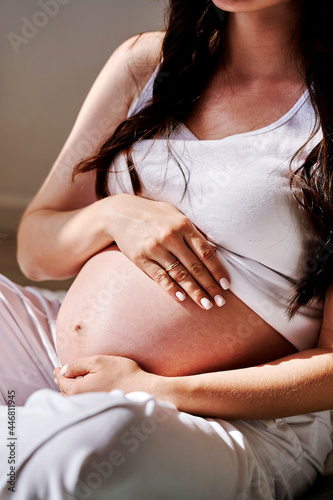 the stomach of a pregnant woman in close-up with an ultrasound image.