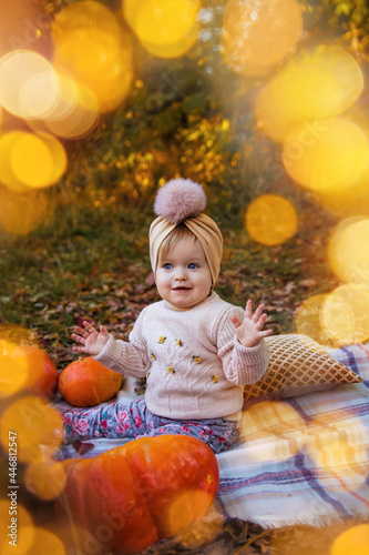 cute little girl sitting in autumn park with lights