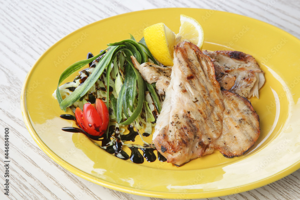 White chicken meat served with arugula on yellow plate White chicken meat served with arugula on yellow plate