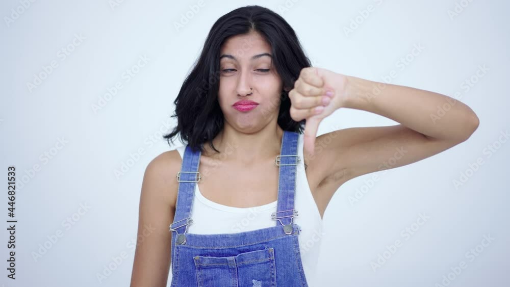 Didn't like it, bad service! Grumpy, dissatisfied brunette woman showing thumbs down gesture and frowning face in displeasure, negative feedback. Indoor studio shot isolated on white background. Didn't like it, bad service! Grumpy, dissatisfied brunette woman showing thumbs down gesture and frowning face in displeasure, negative feedback. Indoor studio shot isolated on white background.