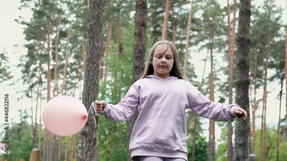 pretty girl tween teenager in purple costume having fun playing with hot air balloons outdoors. holliday, party, birthday, celebration. happy children. slow motion. pretty girl tween teenager in purple costume having fun playing with hot air balloons outdoors. holliday, party, birthday, celebration. happy children. slow motion.