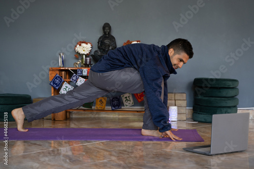 Принти на полотні latin man does yoga postures and virtual meditation at home