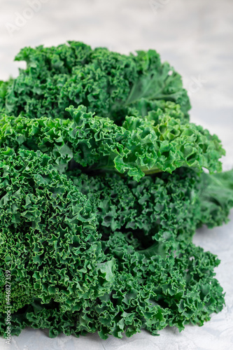 Fresh curly kale leaves on gray background, vertical
