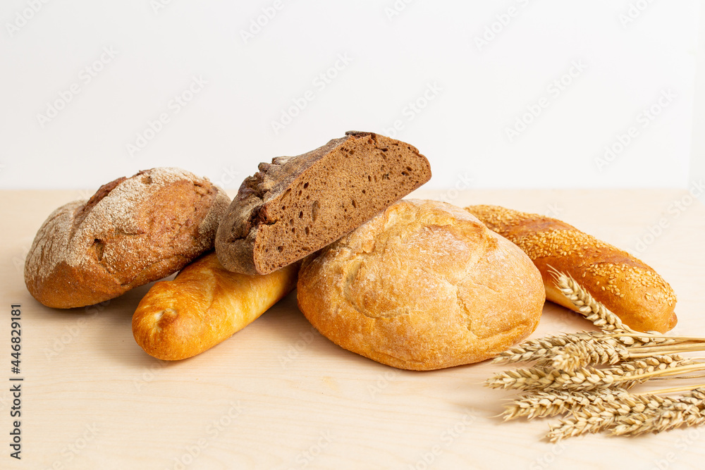baked bread,  fresh bread with wheat ears, bread on a wooden table
