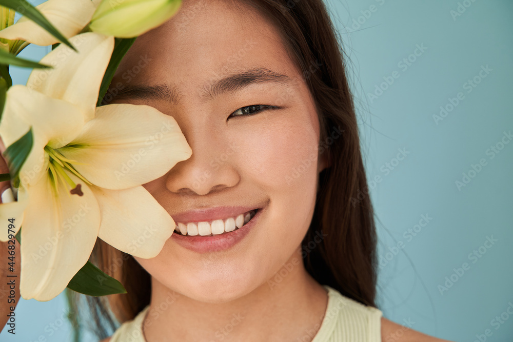 Portrait view of woman face with beautiful tender flowers and nude make-up Portrait view of woman face with beautiful tender flowers and nude make-up