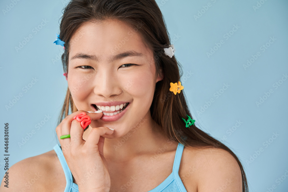 Female with beautiful skin touching face and laughing while looking to the camera Female with beautiful skin touching face and laughing while looking to the camera