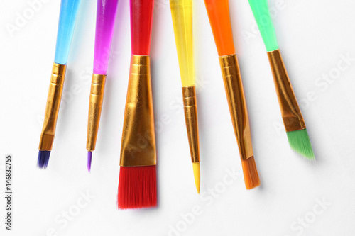 Set of different paintbrushes on white background, top view