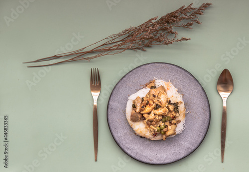 Green curry with chicken (Kaeng kheow hwan with chicken) on top of soft rice noodle on ceramic plate. Authentic Thai food, Copy space, Selective focus. photo