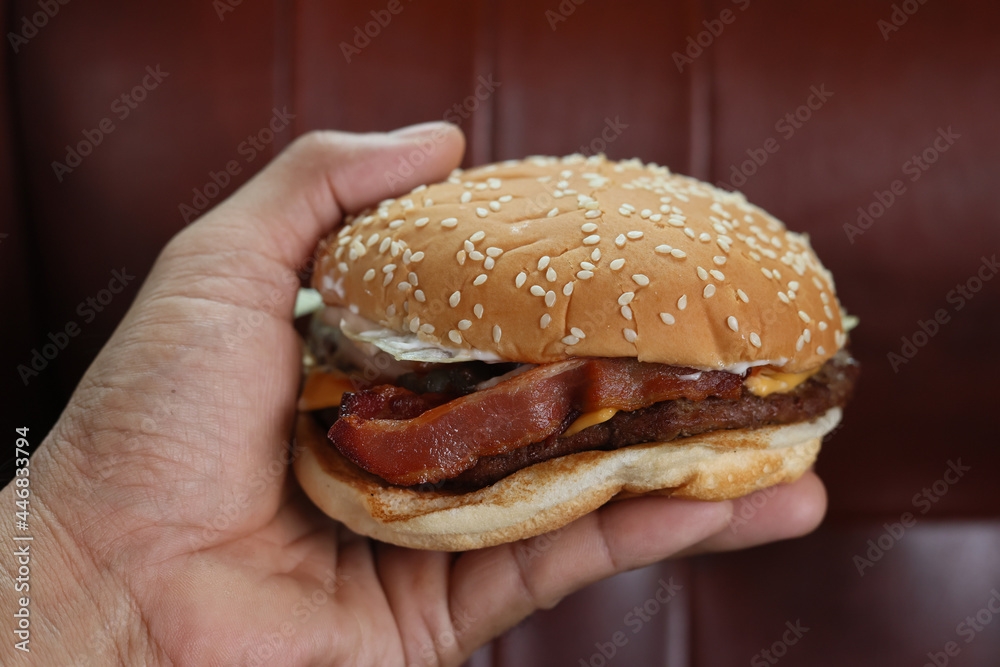 close up shot man holding hands fast food burger, american unhealthy calories meal on red background, mockup with space for text message or design, hungry human with grilled hamburger front view close up shot man holding hands fast food burger, american unhealthy calories meal on red background, mockup with space for text message or design, hungry human with grilled hamburger front view