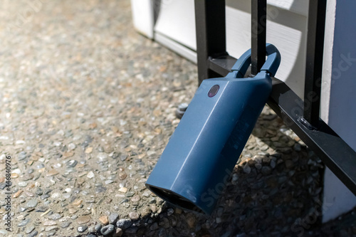 An electronic lockbox activated by a remote code is attached to a home's iron railing. photo