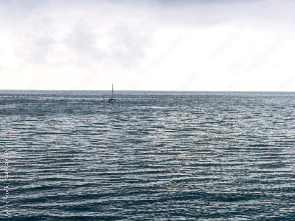 A yacht going on a small sea trip, in cloudy weather and a slight sea disturbance.