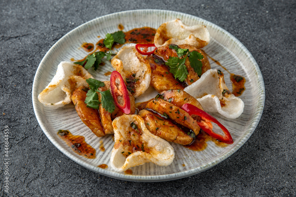 Grilled squid with rice chips sauce. Ready menu for the restaurant. Neutral gray blue textured background Grilled squid with rice chips sauce. Ready menu for the restaurant. Neutral gray blue textured background