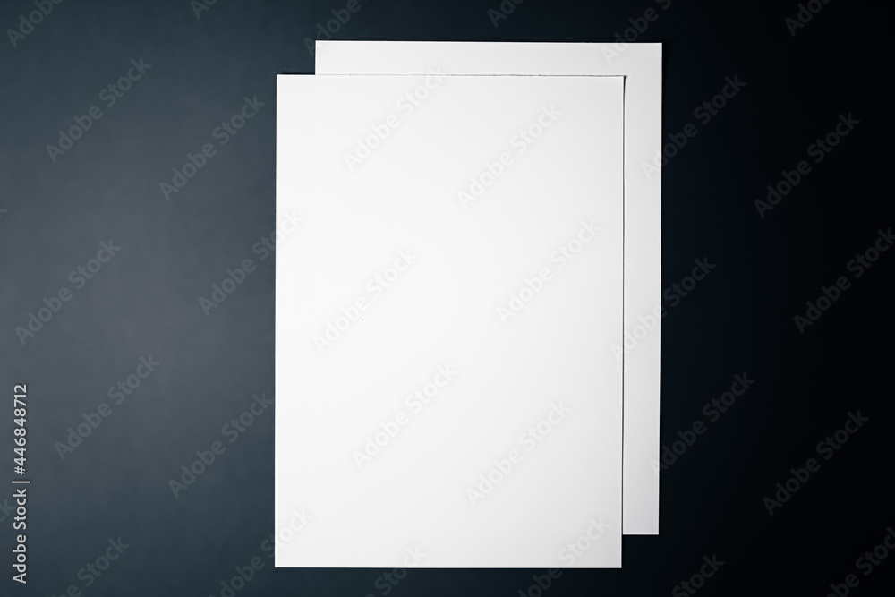 Blank A4 paper, white on black background as office stationery flatlay