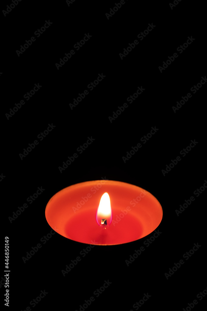 Burning red candle on a black background. Memory concept. Copy space. Vertical orientation. Burning red candle on a black background. Memory concept. Copy space. Vertical orientation.
