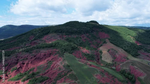 Rougier de Camarès en Aveyron en France. Montagnes et collines rouges d’Occitanie. Forêts, pâturages et champs. Villages de France.