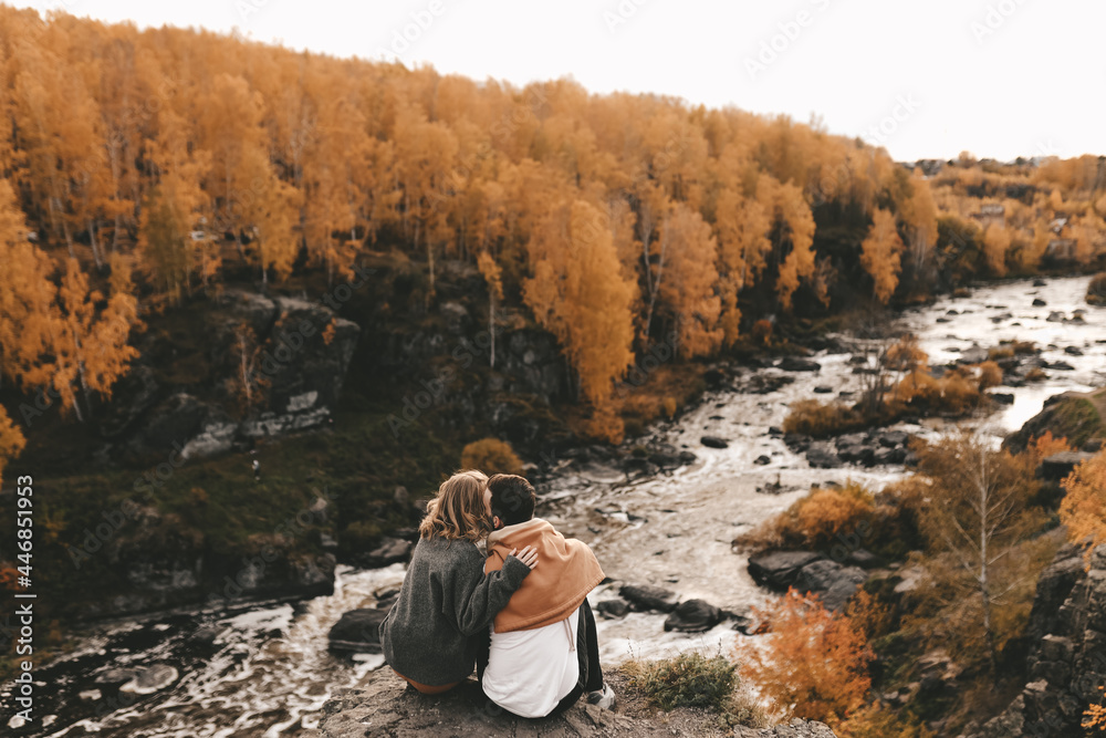Happy cheerful couple in love newlyweds two people in casual clothes travel together hike and walk in the local autumn forest in nature on vacation enjoy the landscape of outdoor activities