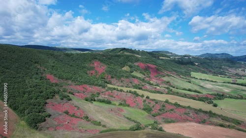 Rougier de Camarès en Aveyron en France. Montagnes et collines rouges d’Occitanie. Forêts, pâturages et champs. Villages de France.