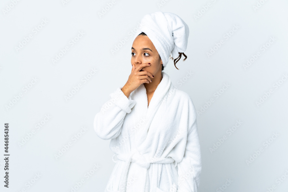 Young woman in bathrobe over isolated white background doing surprise gesture while looking to the side Young woman in bathrobe over isolated white background doing surprise gesture while looking to the side