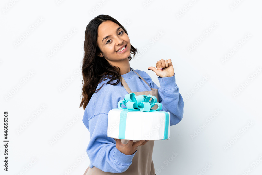 Pastry chef holding a big cake over isolated white background proud and self-satisfied Pastry chef holding a big cake over isolated white background proud and self-satisfied
