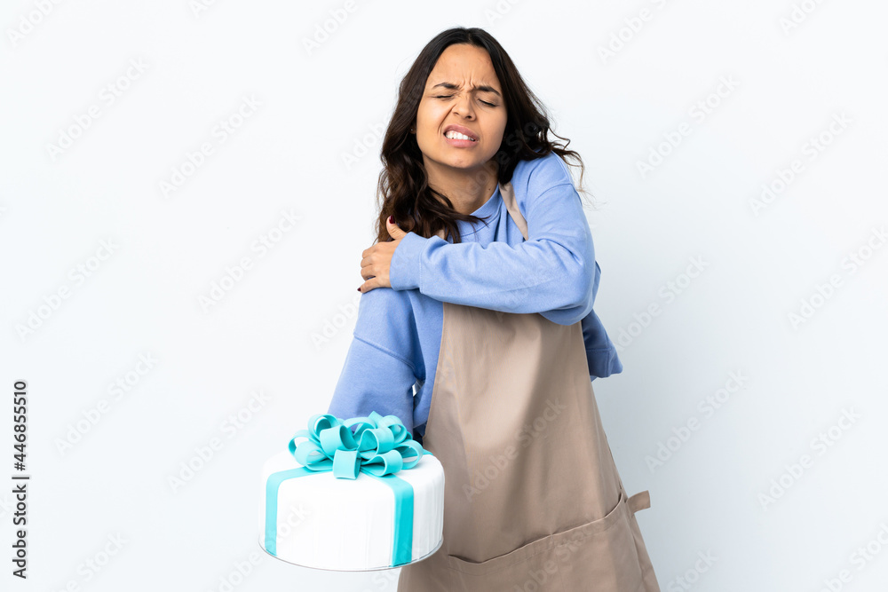 Pastry chef holding a big cake over isolated white background suffering from pain in shoulder for having made an effort Pastry chef holding a big cake over isolated white background suffering from pain in shoulder for having made an effort