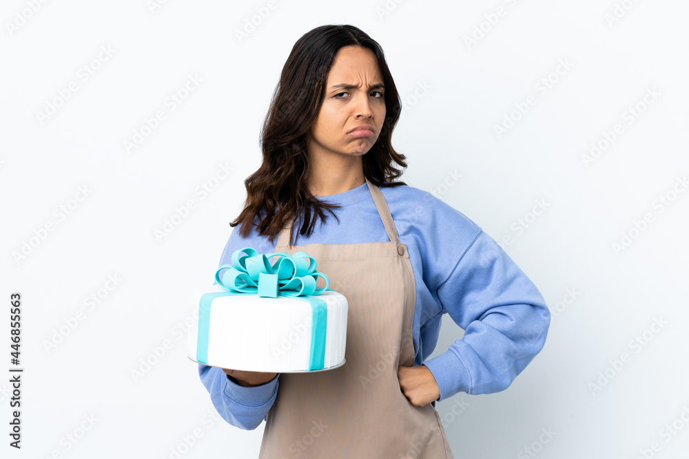 Pastry chef holding a big cake over isolated white background angry Pastry chef holding a big cake over isolated white background angry