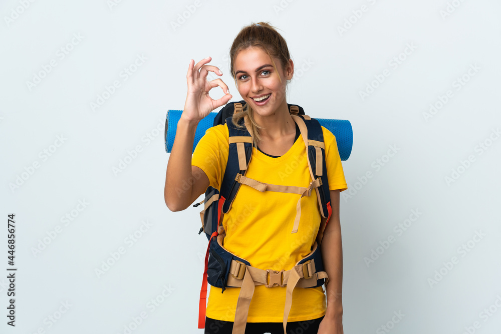 Young mountaineer woman with a big backpack isolated on white background showing ok sign with fingers Young mountaineer woman with a big backpack isolated on white background showing ok sign with fingers
