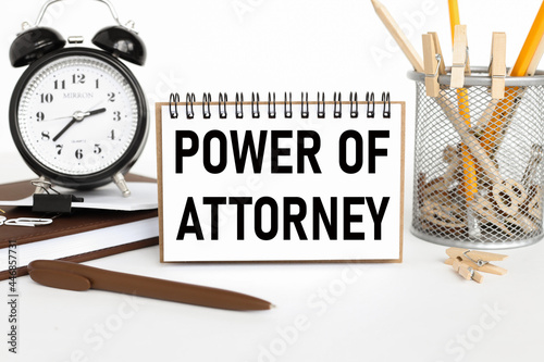 Power Of Attorney, text on business card near pencil case with pencils on white background