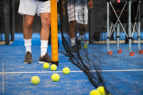 People collectoring balls on a padle or tennis court photo